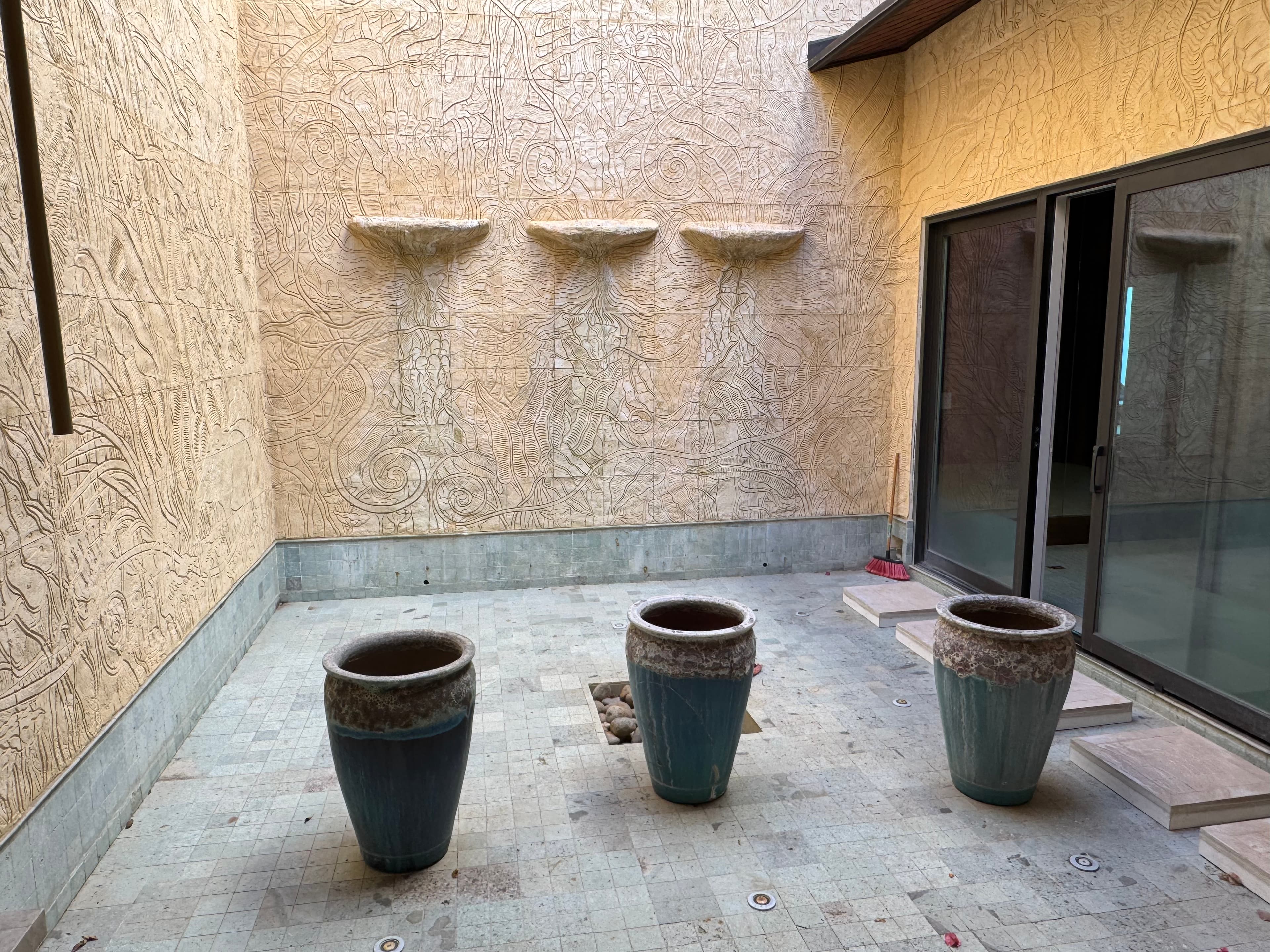 Two-story fountain -- carved bas relief walls by Valenzuela, water cascading to ceramic urns below