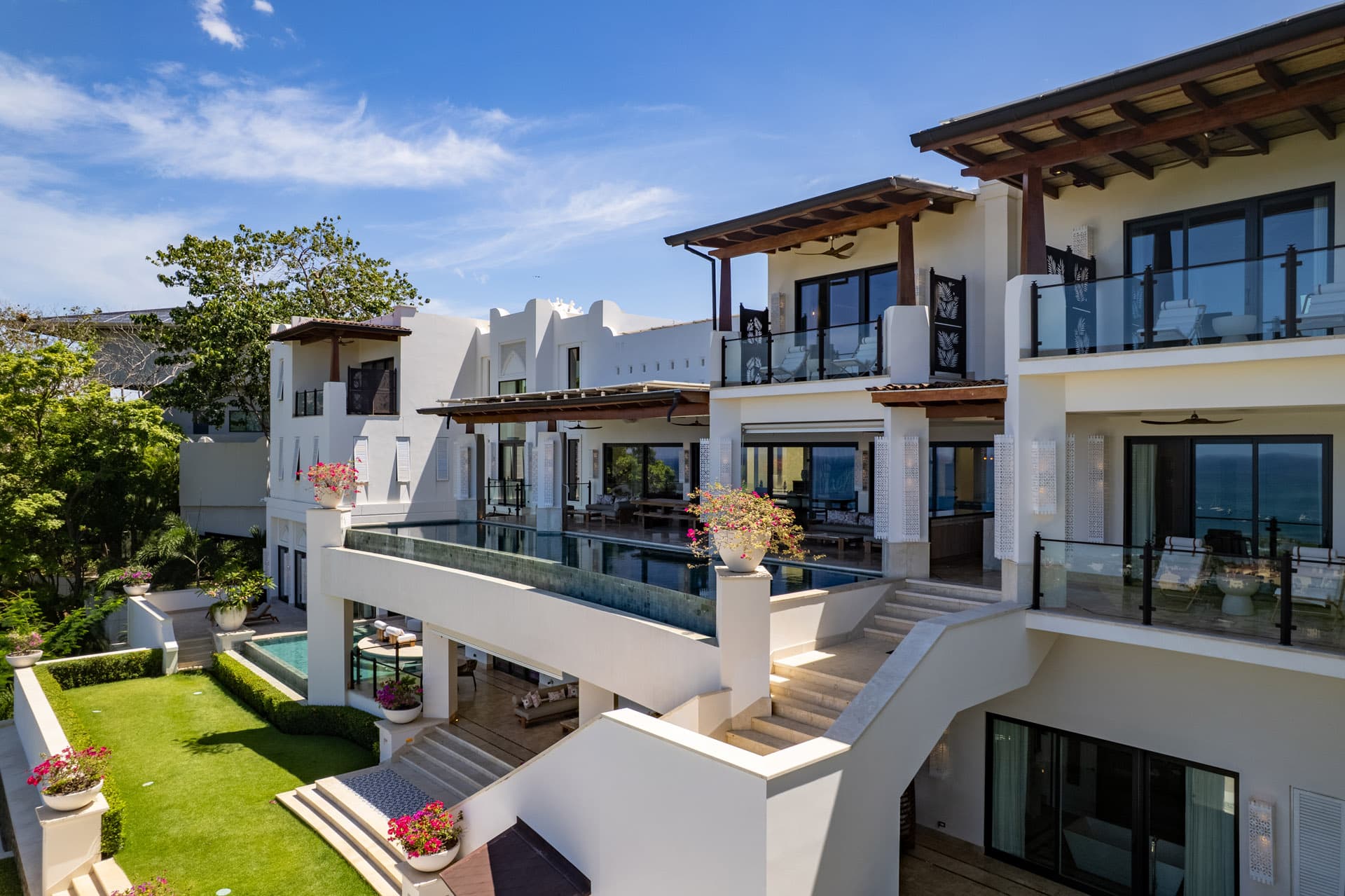 Full exterior facade — bougainvillea, balconies, and infinity pool