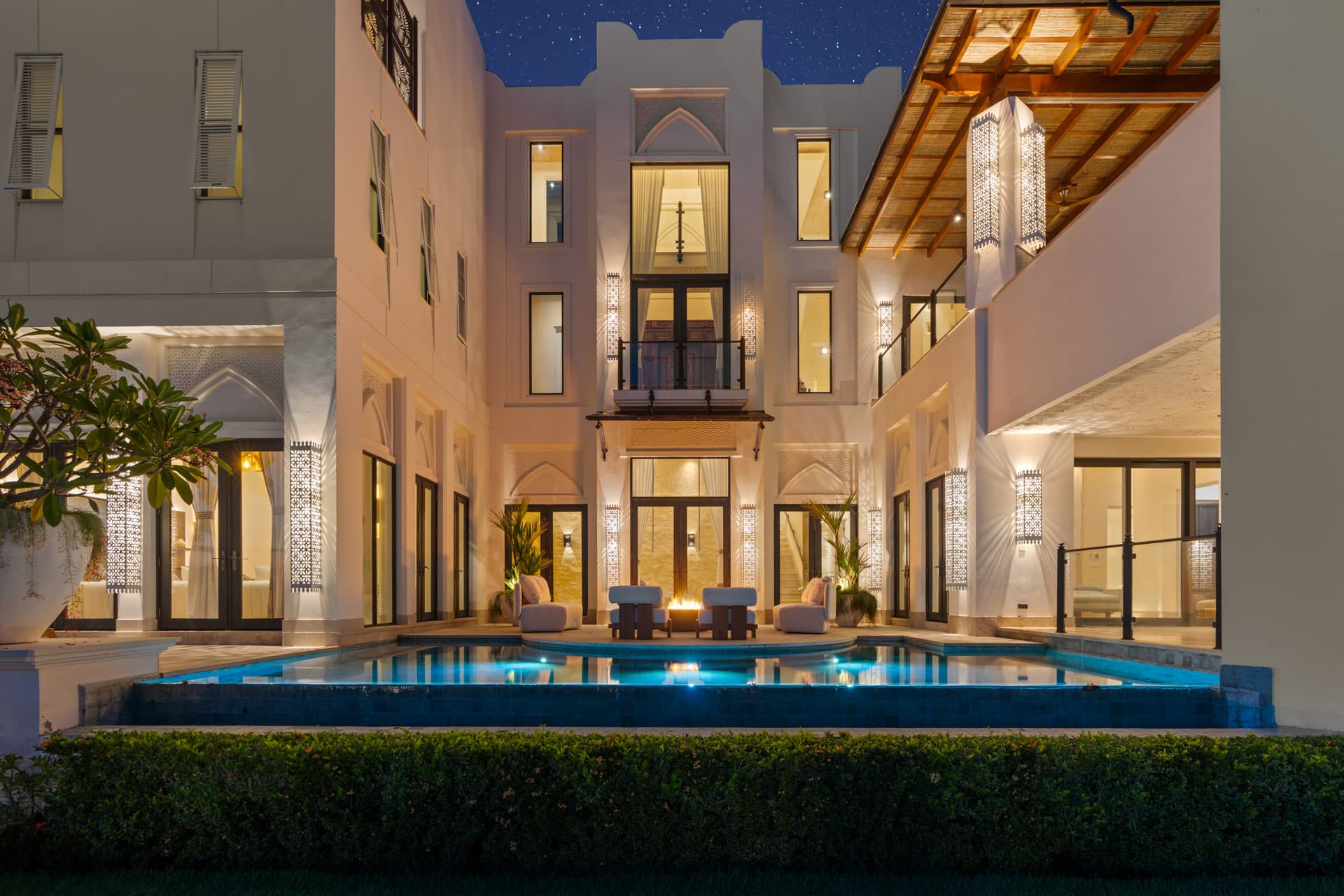 Pool terrace and villa facade glowing at dusk